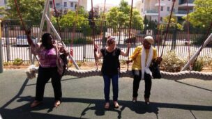 Ayobisi Osuntusa, left, and Fatima Hajju Tomsu Abdul Kadir testing out inclusive playground swings with Beit Issie ShapiroNational Inclusive and Accessible Playground CoordinatorTania Askayo at the original Park Chaverim (Friendship Park).Photo courtesy of Beit Issie Shapiro