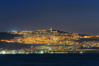 The city of Tiberias lights up the nighttime shore of the Kinneret.