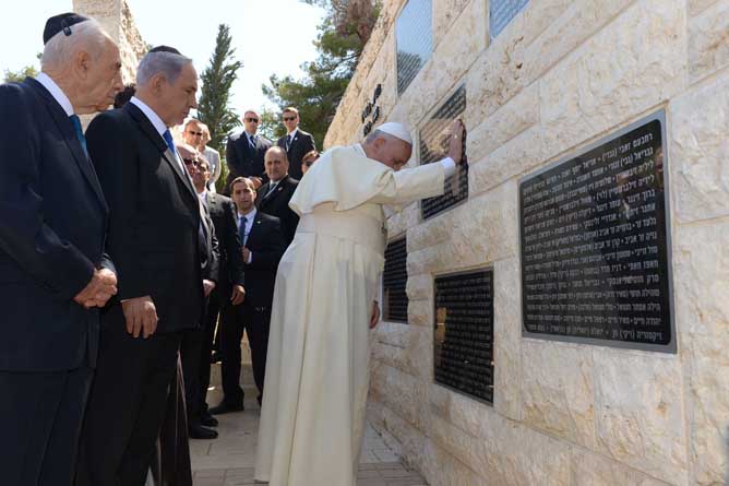 Israeli Prime Minister Benjamin Netanyahu and President Shimon Peres look on as Pope Francis reflects at a monument in honor of victims killed in terror acts, at the Mount Herzl military cemetery in Jerusalem on May 26, 2014.  (Avi Ohayon/GPO/FLASH90)