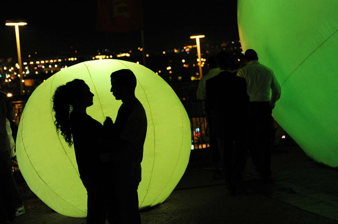 A young couple silhouetted at Jerusalem's Light Festival. Photo by Mendy Hechtman/FLASH90