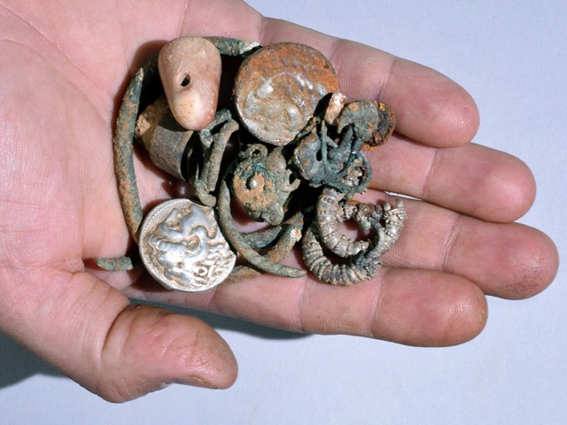 Cache of silver objects: two coins of Alexander of Macedon, rings, bracelets, earrings, and a small stone weight. (Clara Amit, courtesy Israel Antiquities Authority)