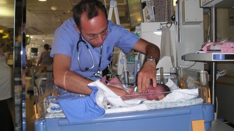 Pediatric cardiologist Dr. Julius Golender preparing a Palestinian baby brought from Hebron by A Heart for Peace for a heart ultrasound at Hadassah Medical Center. Photo by Ron Krumer/Hadassah 
